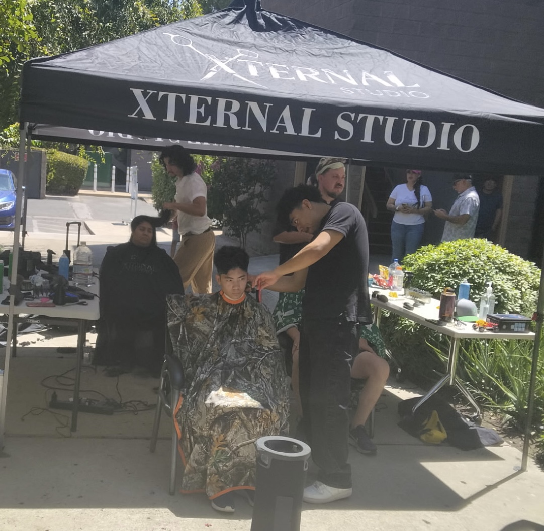 A student receiving a complimentary haircut during an Arise community event